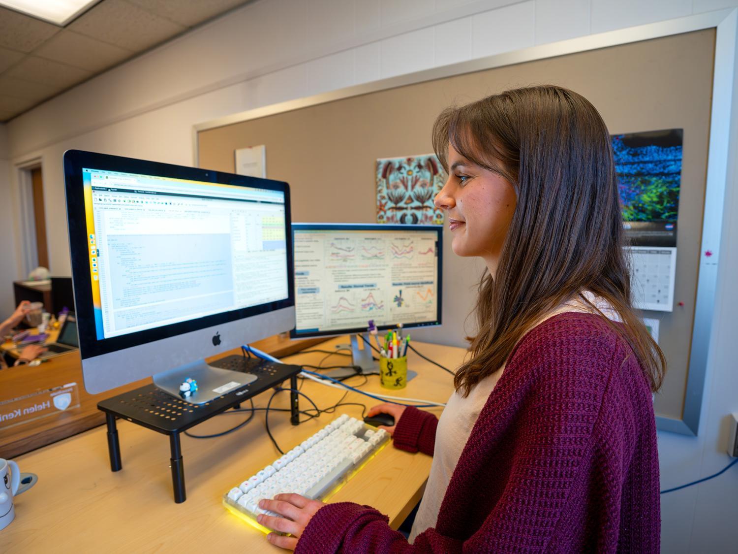 PhD student in Meteorology and Atmospheric Science, Helen Kenion, sitting at a computer working.